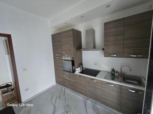 a kitchen with wooden cabinets and a sink at Casa Amy in Acqui Terme