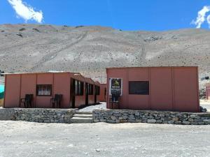 a building in the desert with a mountain in the background at Native Retreat Cottage Lukung in Lukung