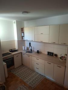 a kitchen with white cabinets and a sink at Apartman IDEA Tuzla in Tuzla