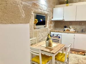 a small kitchen with a wooden table and chairs at Antica Pietra in Polignano a Mare