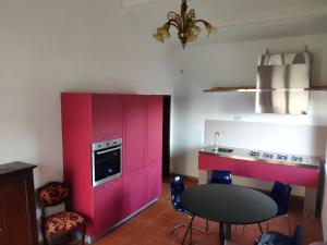 a kitchen with pink cabinets and a table and chairs at Agriturismo Collina degli Ulivi in Sarteano +67 photos