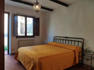a bedroom with a bed with an orange blanket at Agriturismo Collina degli Ulivi in Sarteano