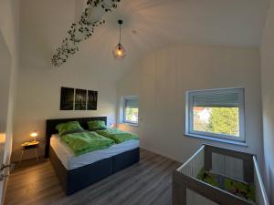 a bedroom with a bed with green pillows on it at Waldzauber - Moderne Ferienwohnung im Grünen in Elpenrod