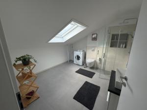 an attic bathroom with a toilet and a window at Waldzauber - Moderne Ferienwohnung im Grünen in Elpenrod