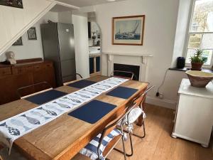 eine Küche mit einem Holztisch mit Stühlen und einem Kühlschrank in der Unterkunft Seacroft - 3 Bed Georgian Listed Townhouse with Wood Burning Stove in Ilfracombe