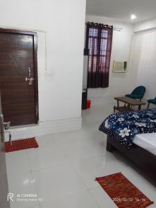 a bedroom with a bed and a window and a table at Golden Lip Hotel in Bhiwadi