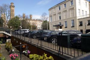 a row of cars parked next to a fence at Acorn Hotel in Glasgow