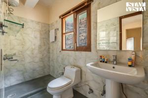 a white bathroom with a sink and a toilet at StayVista at The Marigold with BBQ & Bonfire in Kasauli