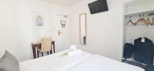 a bedroom with a white bed and a mirror at Hotel de France 18 in Paris