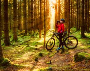 a person on a bike in a forest at Modern villa med spa och pool in Skäralid