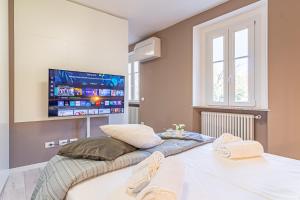 a bedroom with a large bed with a tv on the wall at Isolino Bridge Apartment - Historic Center in Monza