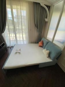 a large white bed with a bow on top of it at Grand Florida芭提雅带免费游泳池温泉桑拿浴和健身房瑜伽室私家海滩公寓E206 in Na Jomtien