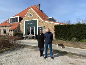 登霍伦B&B Le Commandeur的两个男人带着一只狗站在房子前面