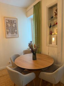 une table de salle à manger avec des chaises et un vase avec des fleurs dans l'établissement Cozy studio in Punavuori, à Helsinki