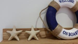 tres estrellas de mar en un estante de madera con una pelota de playa y una toalla en Pensionat Ankargården en Öregrund