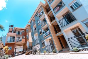 an apartment building with balconies on a street at Perfect Homes Namugongo in Kasiyirize