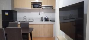 a kitchen with a table and a black refrigerator at San Remo Oasis in Cebu City
