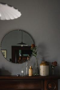 a mirror sitting on top of a dresser with a vase at 101 Oatlands Tasmania in Oatlands