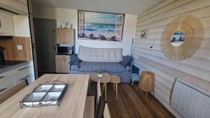 a kitchen and living room with a table and a couch at Appartement seignosse le penon in Seignosse +2 photos