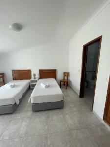 a bedroom with two beds and a bathroom with a mirror at studio para 2 pessoas in Albufeira