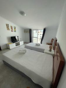 a bedroom with two twin beds and a television at studio para 2 pessoas in Albufeira