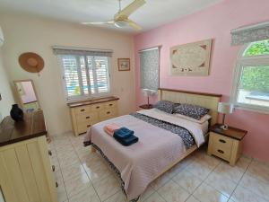 a bedroom with a bed and pink walls and windows at Villa Best Holiday- breathtaking sea views, amazing garden, private pool, BBQ, next to CORAL BAY, Lower Peyia, Paphos in Peyia +129 photos