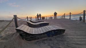 a wooden bench sitting on a pier on the beach at Appartement seignosse le penon in Seignosse