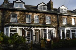 an old brick house with white doors and windows at Ellerbrook House in Windermere