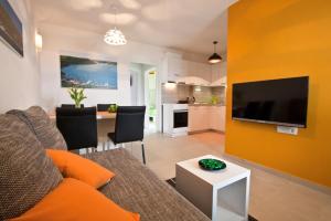 Una sala de estar con un sofá y un televisor en una pared. en Villa Mytilus, a beautiful villa with a fantastic sea view, en Trgetari