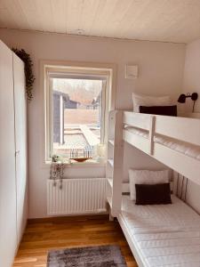 a room with two bunk beds and a window at Modern villa med spa och pool in Skäralid