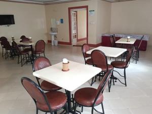 a dining room with white tables and chairs at Good Morning Hotel in Paulo