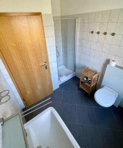 a bathroom with a toilet and a sink and a tub at FeWo-mit-Terasse-u-Garten-am-Golfplatz in Wulfen auf Fehmarn