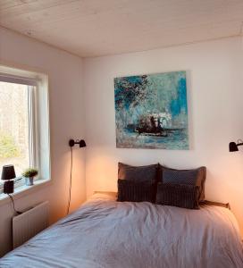 a bedroom with a bed with a painting on the wall at Modern villa med spa och pool in Skäralid +55 photos