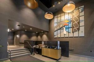 a lobby with a staircase and a painting on the wall at Breath Taking View-4Guest DT Skyline 35th Floor in Calgary
