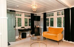 a living room with an orange chair and a table at Boho Manor in Monte Rio