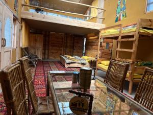 a room with bunk beds and a table and chairs at NotOnMap - H2O House in Chamba