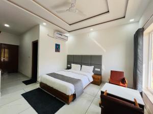 兰斯顿The Shalam Resort श्रीकृष्ण शरणं मम的卧室里有一张床和一把椅子