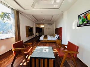 兰斯顿The Shalam Resort श्रीकृष्ण शरणं मम的一间带床、桌椅的酒店房间