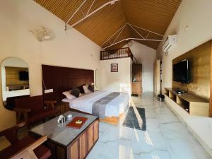 a bedroom with a large bed and a bathroom at The Shalam Resort श्रीकृष्ण शरणं मम in Lansdowne