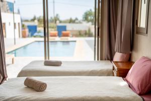 a hotel room with two beds and a swimming pool at ,,,''' Sidi kaouki Tayoukhte Surf House with Pool ''' ,,, Surfing lessons, Horse Riding & Quad adventures ,,, Local experiences all in one place in Sidi Kaouki