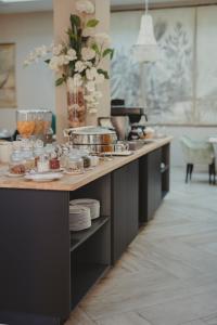 a kitchen with a counter with dishes and a vase of flowers at Hôtel Spa Marotte in Amiens