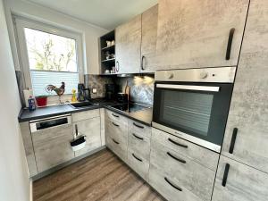 a kitchen with wooden cabinets and a large window at 3500 Weitblick über das Land in Grönwohldshorst
