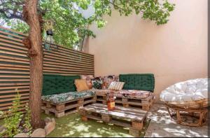 un patio avec deux canapés verts et un arbre dans l'établissement BBQ-terrasse Ombragée-proche hypercentre, à Toulon