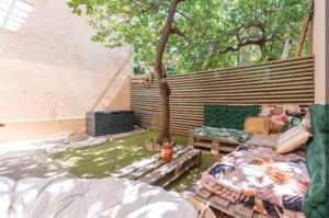 un patio avec un canapé, une table et un arbre dans l'établissement BBQ-terrasse Ombragée-proche hypercentre, à Toulon 4 autres photos