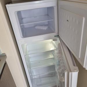 an empty refrigerator with its door open in a kitchen at mobilhome au domaine des iscles emplacement 137 in La Roque-dʼAnthéron