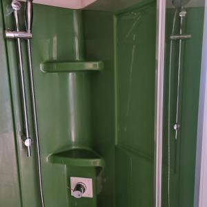 a green bathroom with a toilet with a green wall at mobilhome au domaine des iscles emplacement 137 in La Roque-dʼAnthéron