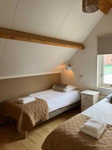 a bedroom with two beds and a window at Vakantiewoning in villapark de oesterbaai 113 in Wemeldinge