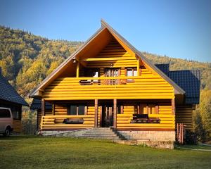 a large wooden house with a mountain in the background at Котедж Зелениця in Zelenitsa