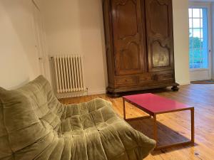 a living room with a couch and a table at Maison de campagne avec grande piscine in Agonac