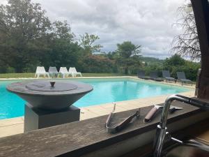 a swimming pool with a stone fountain next to a swimming pool at Maison de campagne avec grande piscine in Agonac